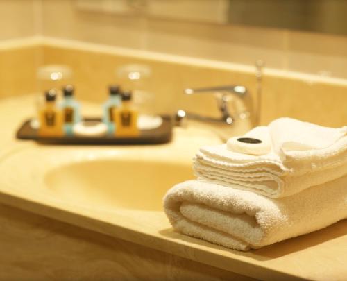 a bathroom sink with towels on a counter at Killarney Towers Hotel & Leisure Centre in Killarney