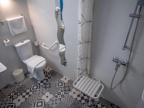 La petite salle de bains est pourvue d'une douche et de toilettes. dans l'établissement Contact Hotel Restaurant Bleu France - Eragny Cergy, à Éragny