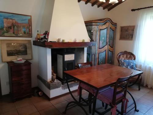 ein Esszimmer mit einem Tisch und einem Kamin in der Unterkunft Casa Crevole in Palazzina