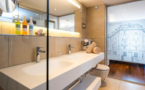 ein Badezimmer mit einem großen Waschbecken und einem WC in der Unterkunft Hotel Scheuble in Zürich
