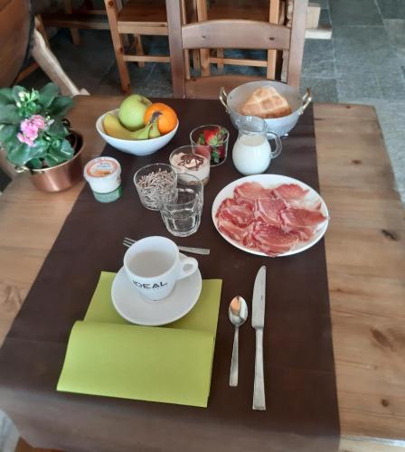 una mesa con un plato de carne y una taza de café en Adda Vegia, en Buglio in Monte