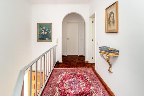 a hallway with a staircase with a rug on the floor at Elegant Vintage Villa- Parede in Parede