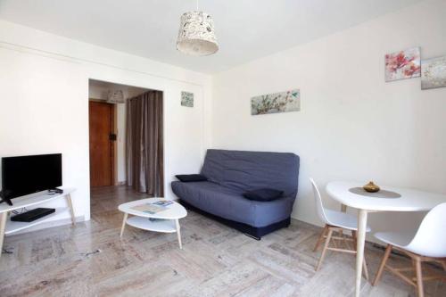 un salon avec un canapé bleu et une table dans l'établissement Studio à Nice ensoleillé proche centre et plage, à Nice