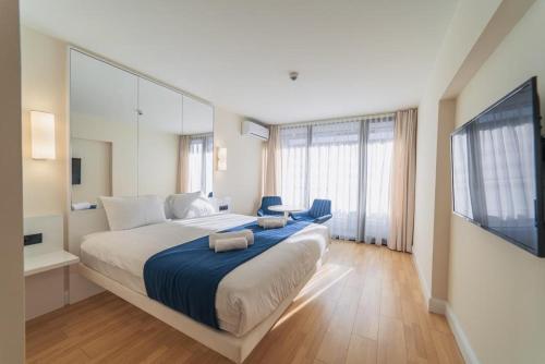 um quarto grande com uma cama grande e uma televisão em ORBI GROUP APART-HOTEL em Batumi