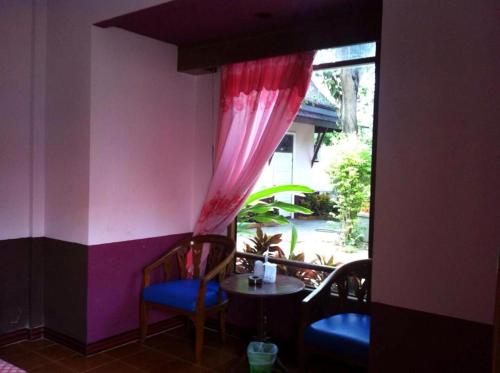 Habitación con mesa, sillas y ventana en Sweet Inn Resort, en Bang Pahan