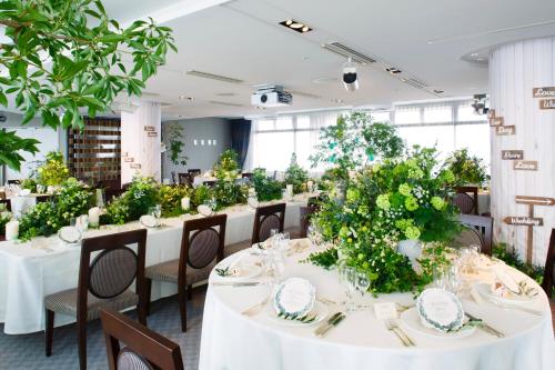 a long table with white table cloths and plants at ANA Crowne Plaza Narita by IHG in Narita