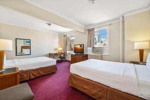 a hotel room with two beds and a television at Travelodge by Wyndham Downtown Chicago in Chicago