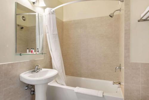a bathroom with a sink and a toilet and a shower at Travelodge by Wyndham Downtown Chicago in Chicago
