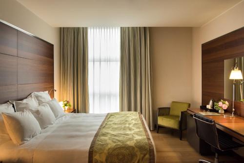 a hotel room with a bed and a desk at Best Western Premier BHR Treviso Hotel in Quinto di Treviso