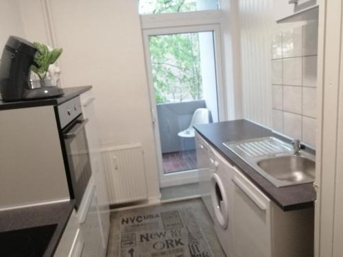 a small kitchen with a sink and a stove at Kölsche Wohnung 2C in Cologne