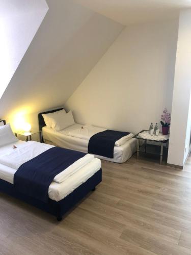 a bedroom with two beds and a table with flowers at Hotel Johann in Warendorf