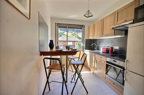 - une cuisine avec une petite table et des chaises dans l'établissement APPARTEMENT LUMINEUX AVEC 2 BALCONS - MORZINE - 6 PERSONNES - NANTAUX 17 B, à Morzine
