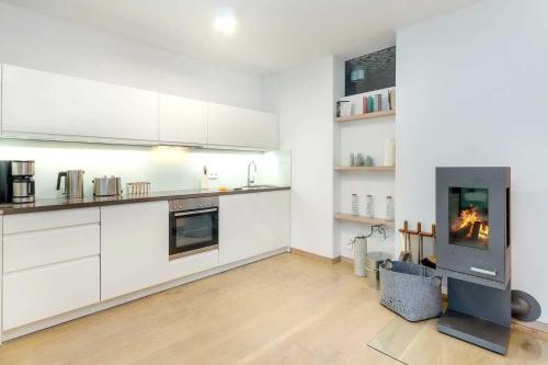 eine Küche mit weißen Schränken und einem Kamin in der Unterkunft die Strandvilla Nordlicht in Ostseebad Sellin