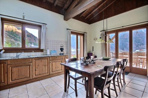 une cuisine avec une table en bois et quelques chaises dans l'établissement CHALET - WIFI - SAINT JEAN D'AULPS - 10 Personnes - TAPTOP, à Saint-Jean-dʼAulps