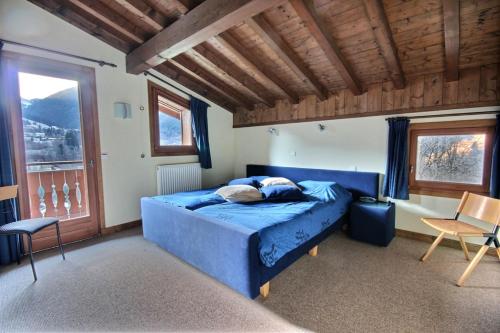 1 dormitorio con sofá azul en una habitación con ventanas en CHALET - WIFI - SAINT JEAN D'AULPS - 10 Personnes - TAPTOP en Saint-Jean-dʼAulps