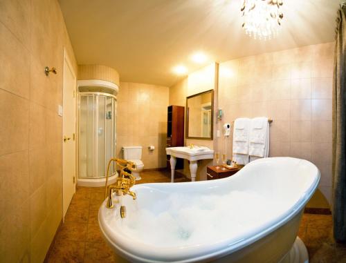 La salle de bains est pourvue d'une baignoire et d'un lavabo. dans l'établissement Hôtel Baker, à Gaspé