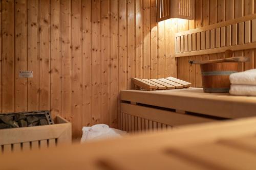 a bathroom with wooden walls and towels on shelves at Vier Häuser in Norderney
