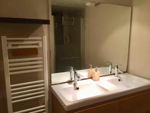 La salle de bains est pourvue d'un lavabo et d'un grand miroir. dans l'établissement Loft in Rennes - Private room, à Rennes