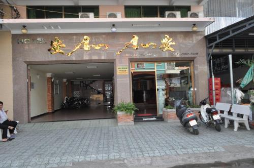 una tienda frente a un edificio con escritura de oro. en An An Hotel en Rạch Giá