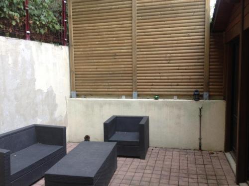 deux bancs noirs assis devant un mur dans l'établissement Loft in Rennes - Private room, à Rennes
