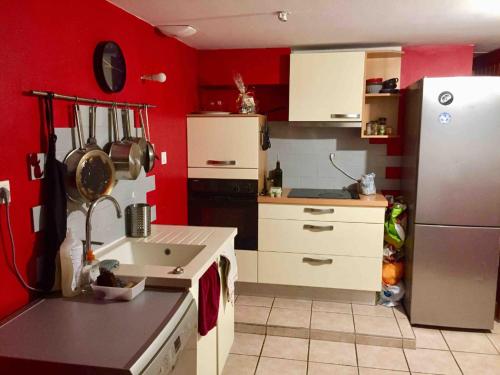 a kitchen with red walls and a white refrigerator at Loft in Rennes - Private room in Rennes