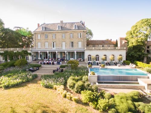 een groot huis met een zwembad ervoor bij Chateau de Blomac in Blomac