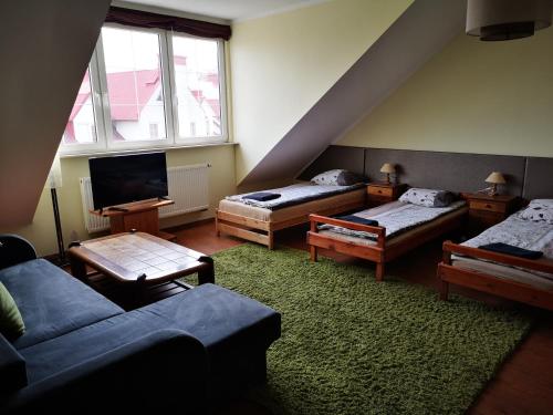 a living room with two beds and a couch at Apartamenty Sokółka in Sokółka