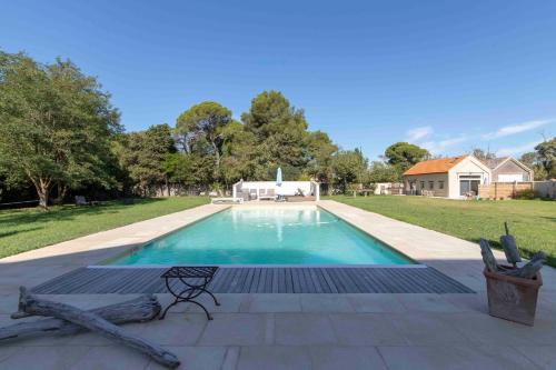 a swimming pool in a yard with a house at Maébrilu Camargue Provence in Salin-de-Giraud