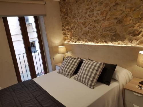 een slaapkamer met een bed met 2 kussens erop bij Casa Murada in Tivissa