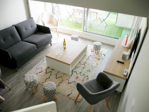 a living room with a couch and a table and chairs at Appartement duplex 5 personnes vue sur le port de la Trinité Sur Mer in La Trinité-sur-Mer