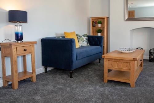 a living room with a blue chair and a table at Beresford Dale in Ashbourne