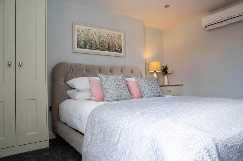 a bedroom with a bed with pink and blue pillows at Beresford Dale in Ashbourne