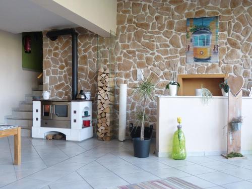 a kitchen with a stove and a stone wall at Gästehaus Steker in Bad Driburg