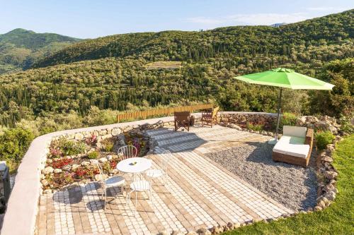 a patio with a table and an umbrella at Mounty Island Villas-Nefeli in Lazaráta