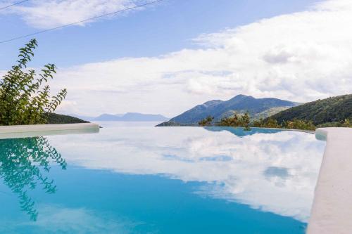 a pool with a view of the water and mountains at Mounty Island Villas-Nefeli in Lazaráta