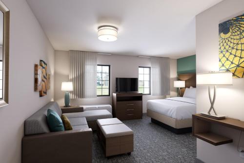 a hotel room with a bed and a couch at Staybridge Suites Sterling Heights - Detroit by IHG in Sterling Heights