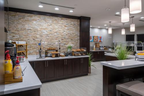a kitchen with a brick wall and aasteryasteryasteryasteryasteryasteryasteryastery at Staybridge Suites Houston East - Baytown by IHG in Baytown