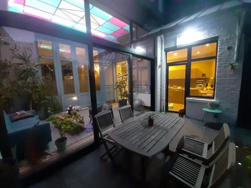 una casa con patio con mesa y 2 sillas en Maison du jardin botanique, en Tourcoing