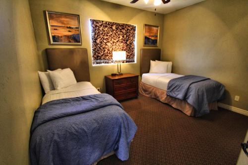 a hotel room with two beds and a lamp at Canyon Villas at Coral Ridge in Washington