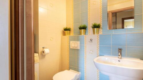 a bathroom with a sink and a toilet at VacationClub - Gryfa Pomorskiego 77D Apartament 34A in Międzyzdroje
