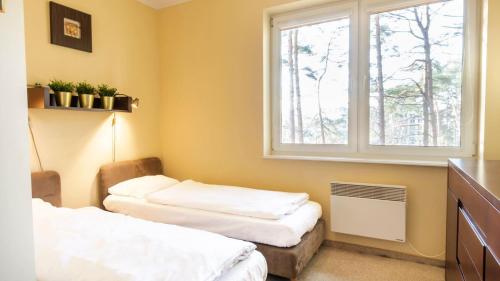 een kamer met 2 bedden en een raam bij VacationClub - Gryfa Pomorskiego 77D Apartament 34A in Międzyzdroje