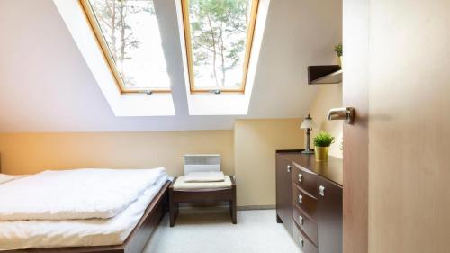a bedroom with a bed and two skylights at VacationClub - Gryfa Pomorskiego 77D Apartament 34B in Międzyzdroje