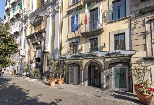 a building on a street with potted plants on the sidewalk at Palazzo Turchini in Naples