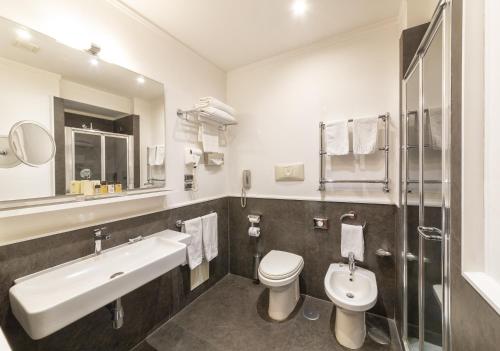 a white bathroom with a sink and a toilet at Palazzo Turchini in Naples