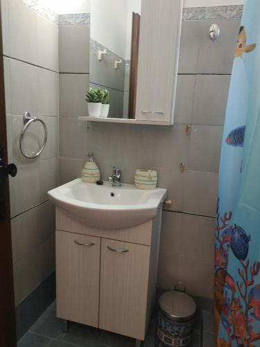 a bathroom with a sink and a mirror at Παραθαλασσια στουντιο Μιχαλιας Sea view studio Michalias in Agia Marina Aegina