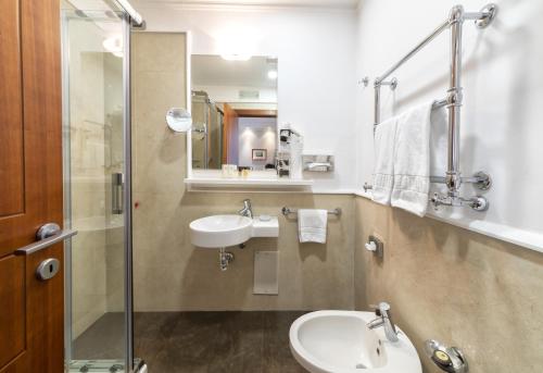 a bathroom with a sink and a toilet and a mirror at Palazzo Turchini in Naples