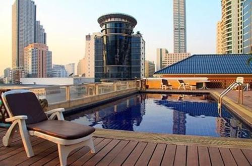a chair sitting on top of a building with a pool at King Royal Garden Inn in Bangkok