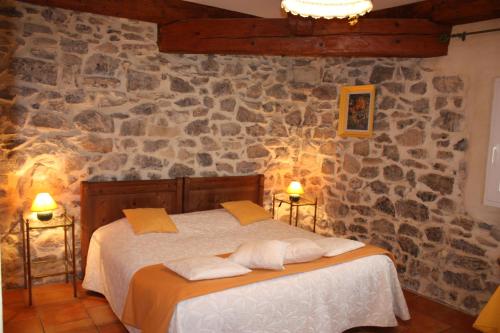 a bedroom with a bed in a stone wall at Domaine de "Creva-Tinas" in Pouzols-Minervois