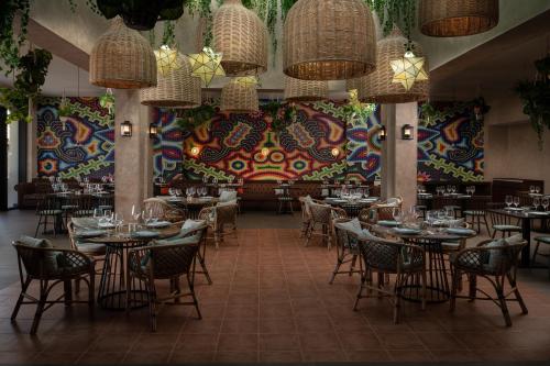 a restaurant with tables and chairs and a colorful wall at Dreams Macao Beach Punta Cana in Punta Cana