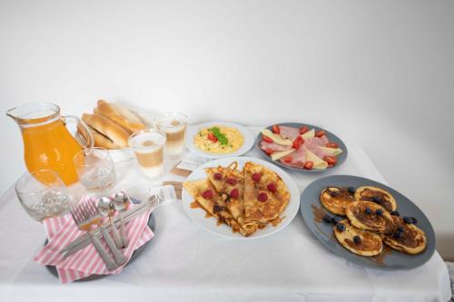 a table topped with plates of breakfast foods and drinks at VIP suite hotel Heinz in Dobříš